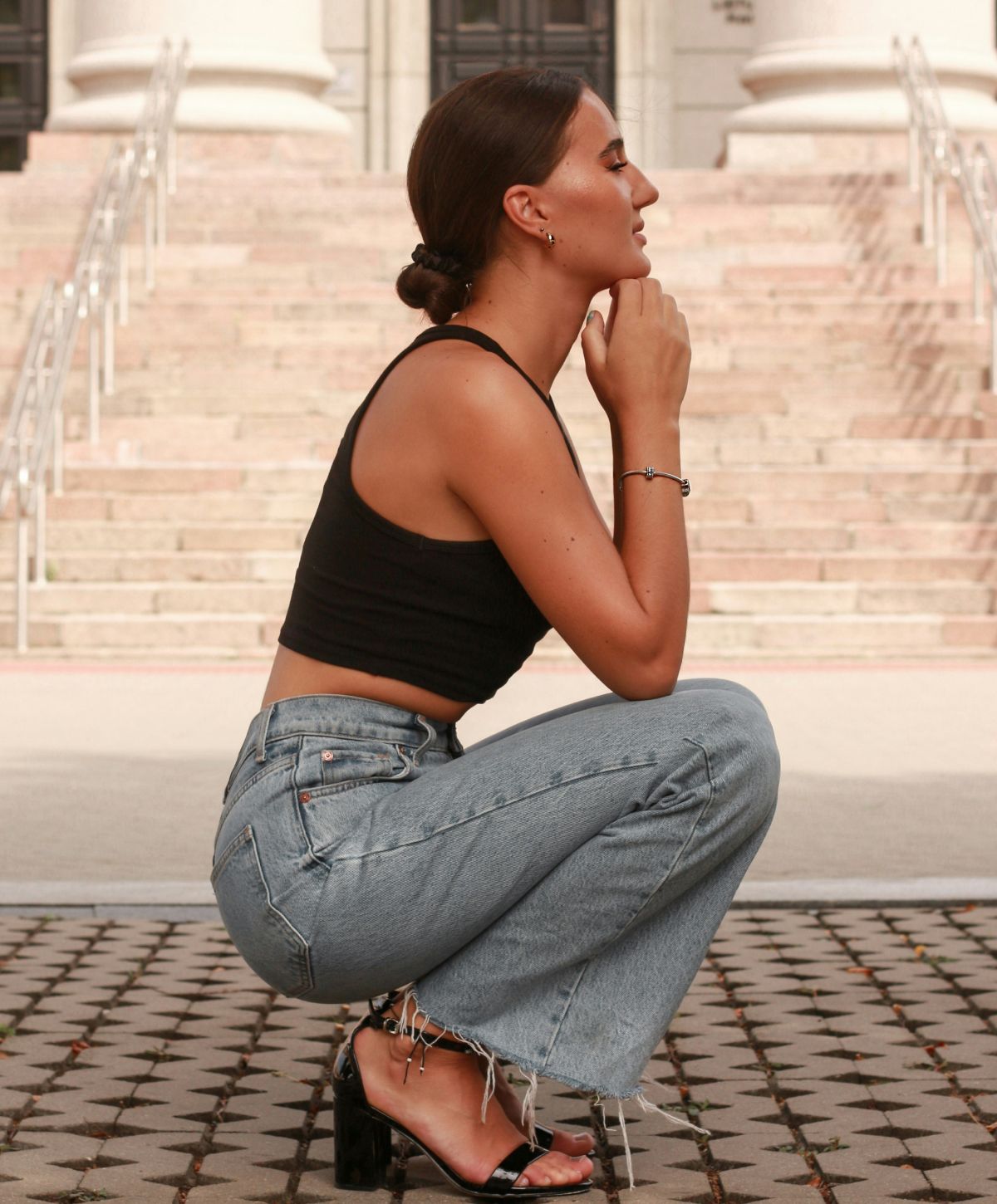 Woman smiling on a bed, sunlight streaming in.