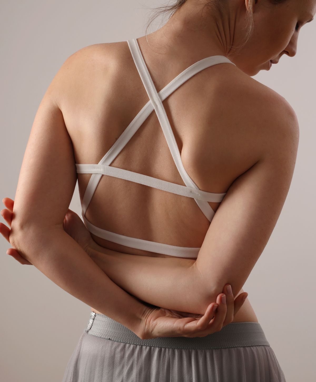 Back view of woman in strappy outfit.