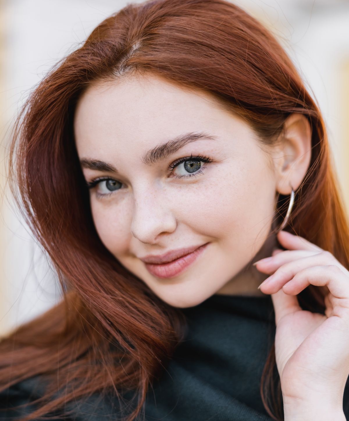 Smiling woman with red hair and freckles.