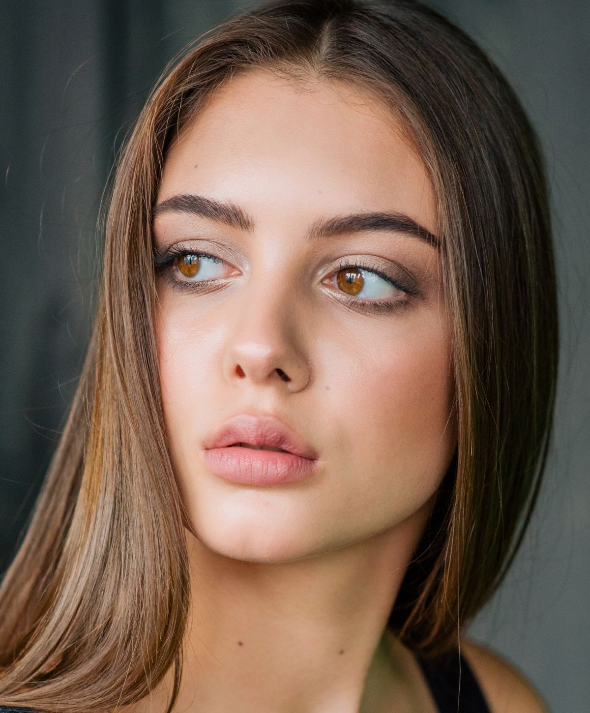 Young woman with long hair and soft makeup.