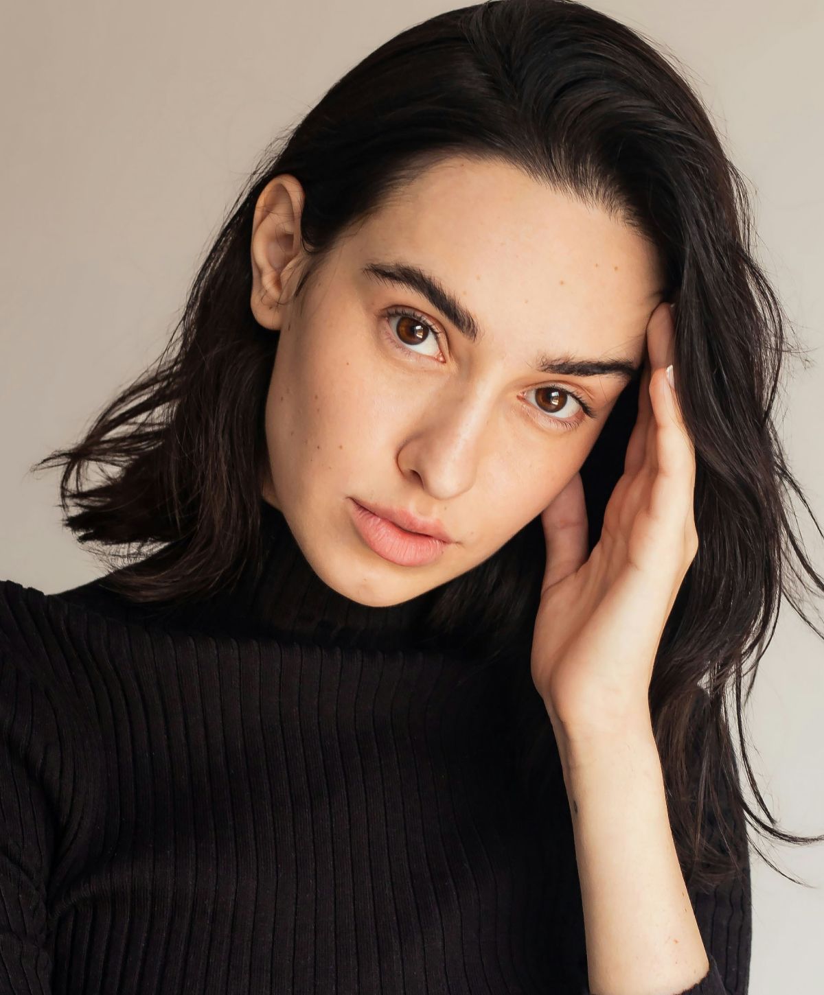 Woman with long hair in a black sweater.
