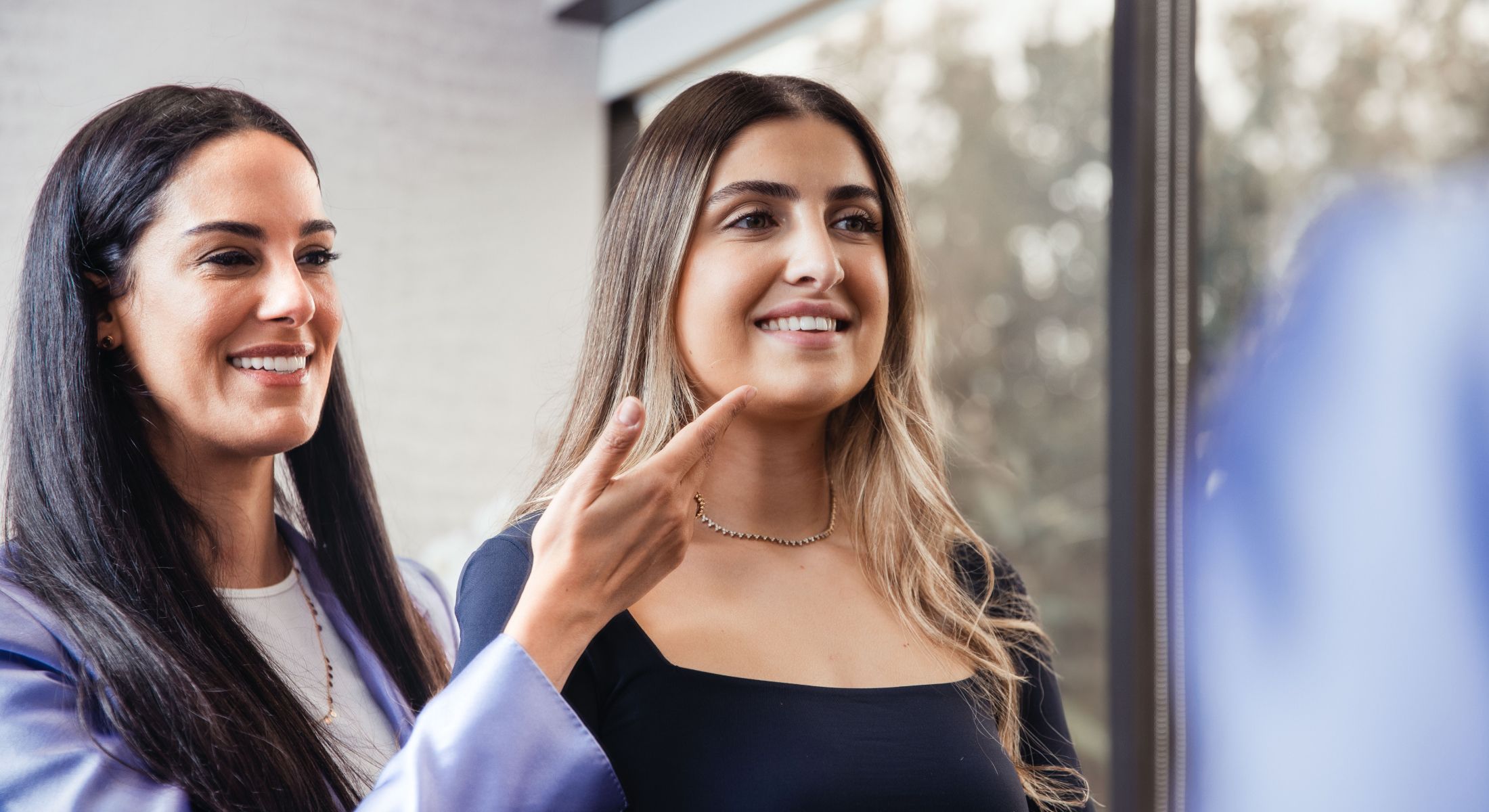 Women interacting, one giving guidance or feedback.