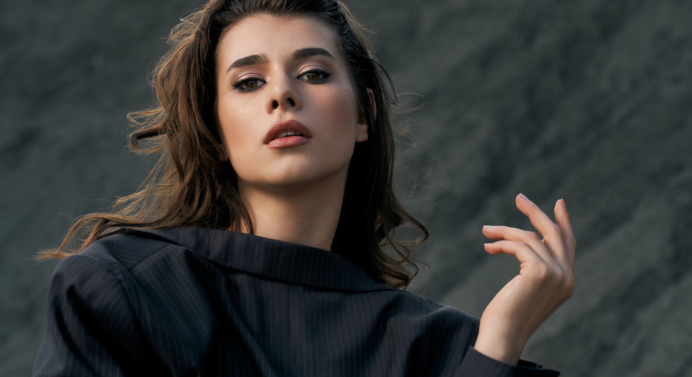 Fashion model posing against a textured background.