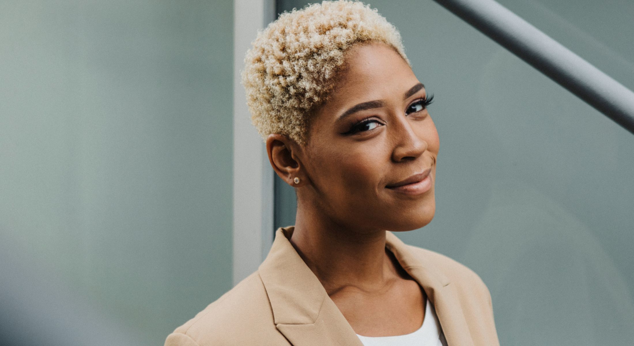 Smiling woman with short curly hair.